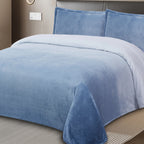 Blue textured blanket and pillows on a bed in a bedroom setting.