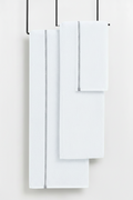 Set of white towels hanging on a rack against a white background