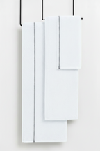 Set of white towels hanging on a rack against a white background