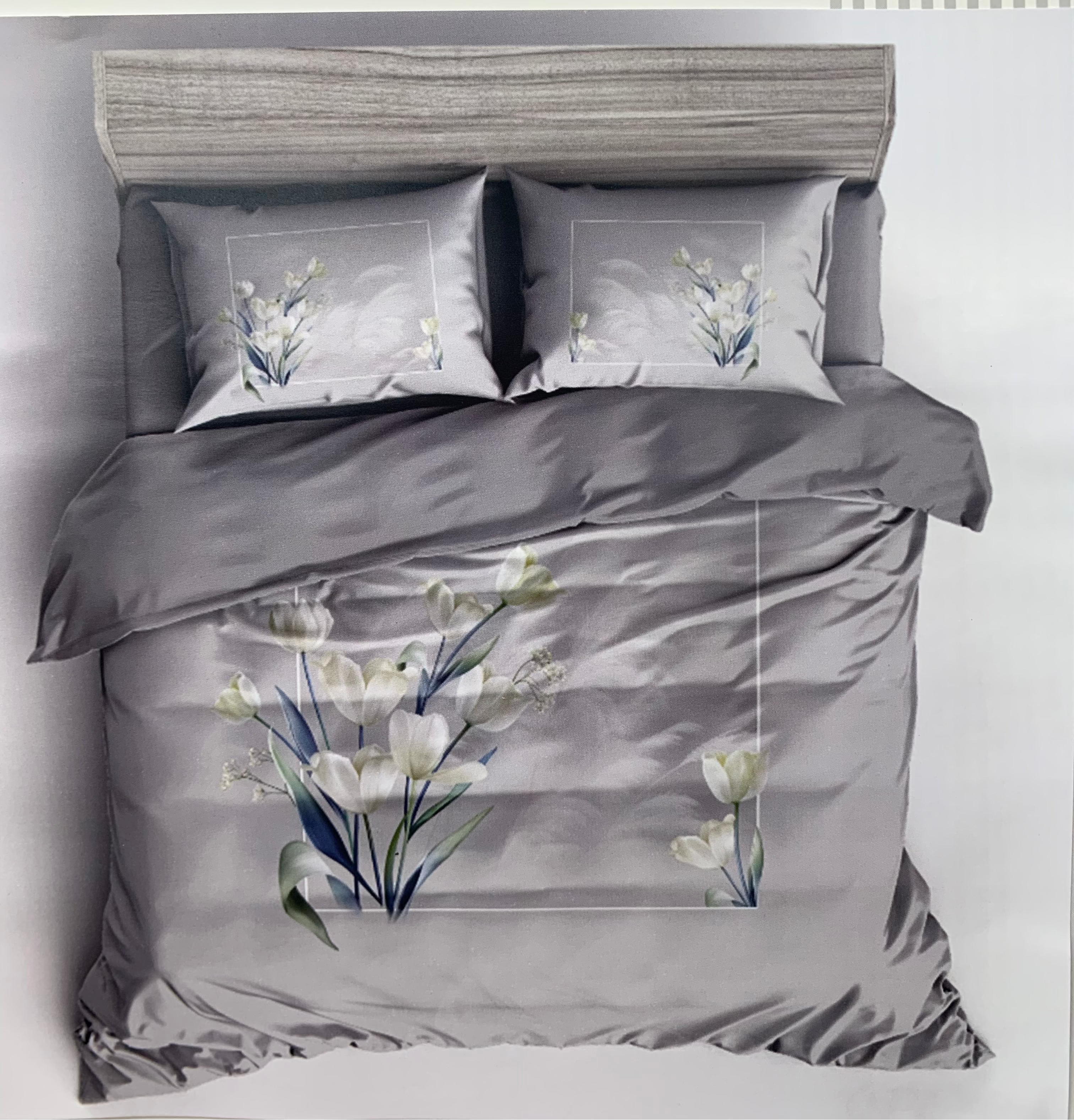 Gray bedding set with floral patterns on a bed against a white background, featuring the brand 'Rochelle France'.