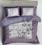 Floral bedding set with matching pillows on a bed, branded 'Rochelle France'.