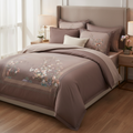 Bedroom with a bed featuring floral printed bedding and matching pillows.