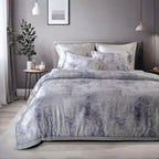 Gray textured duvet cover set on a bed in a bedroom with a plant and framed picture on the wall.