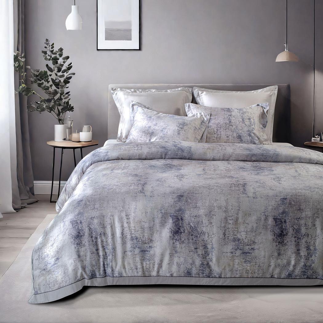 Gray textured duvet cover set on a bed in a bedroom with a plant and framed picture on the wall.