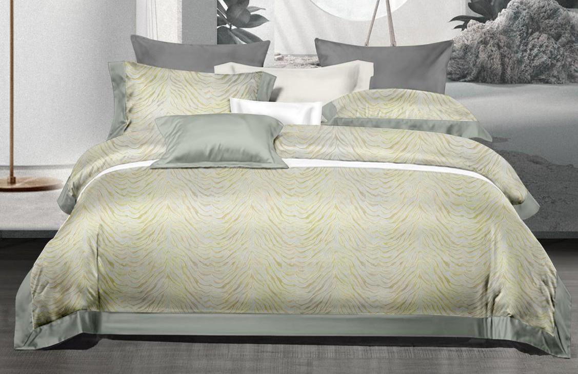 Neatly made bed with green and gray bedding in a modern bedroom setting.