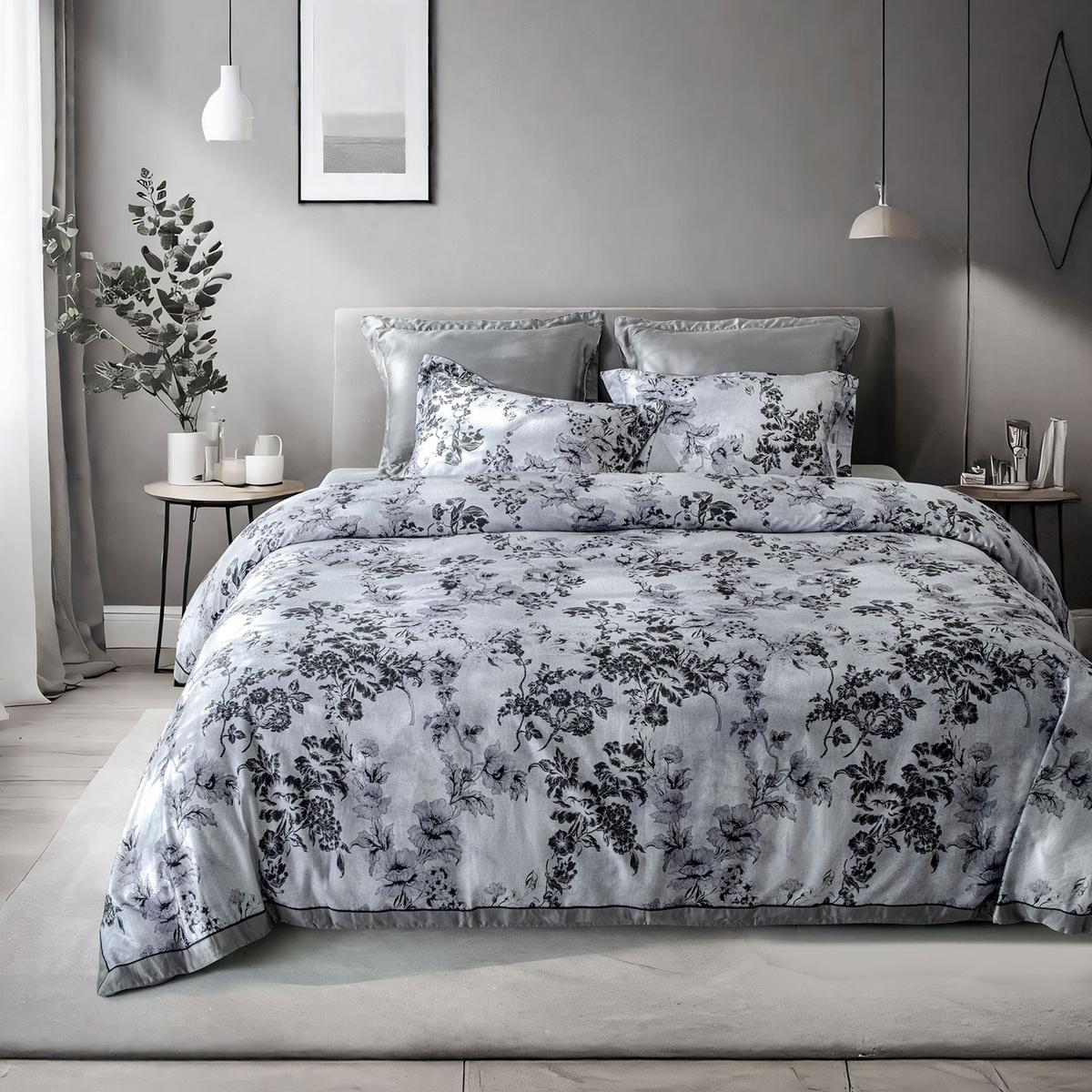 Floral patterned bedding set on a bed in a bedroom with gray walls and decor.