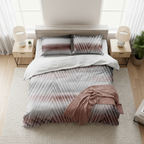 Bed with patterned bedding and pillows on a plain background