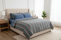 Bedroom with a bed featuring striped blue Quilt.